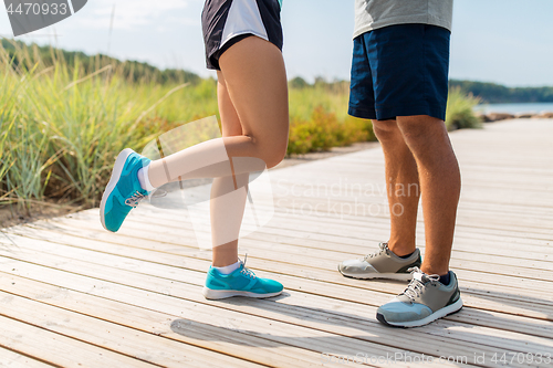 Image of legs of couple of sportsmen in sneakers outdoors