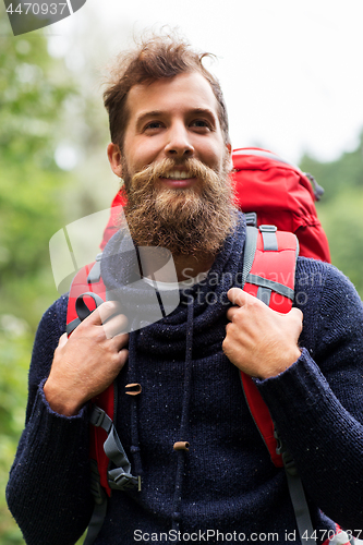 Image of bearded traveler with backpack in woods