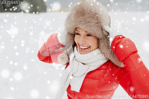 Image of happy woman in winter fur hat outdoors