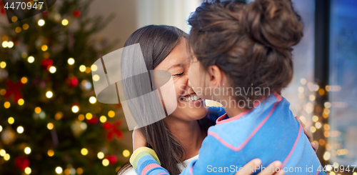 Image of happy daughter kissing her mother on christmas