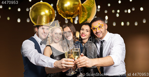 Image of happy friends clinking champagne glasses at party