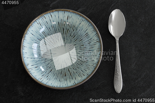 Image of close up of ceramic plate and spoon on table