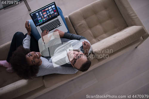 Image of happy multiethnic couple relaxes in the living room