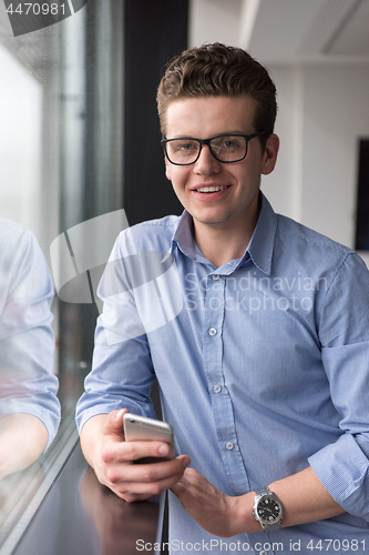 Image of Businessman Standing In A Modern Building Near The Window With P