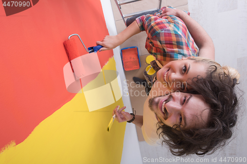 Image of couple painting interior wall