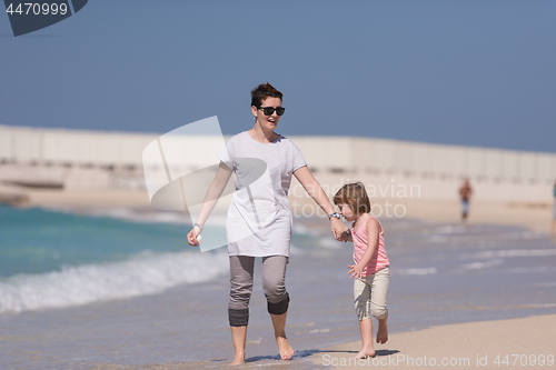 Image of mother and daughter running on the beach
