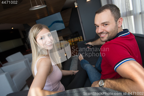 Image of Young couple on the sofa watching television