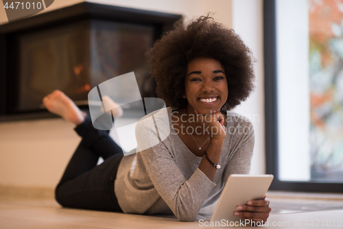 Image of black women using tablet computer on the floor