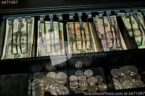 Image of US dollars and coins in open cash drawer