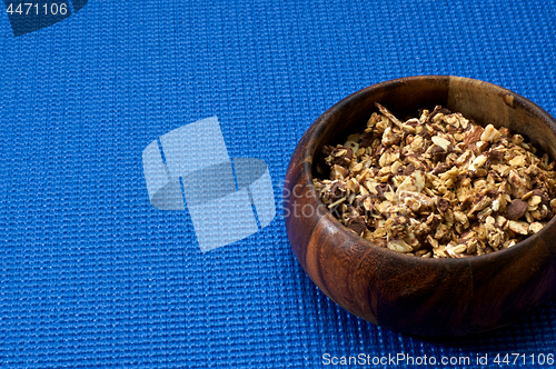 Image of wooden bowl with granola blue background