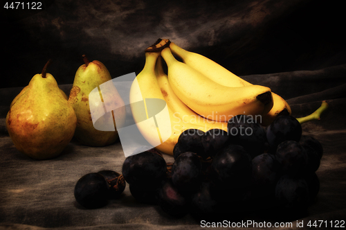 Image of grapes pears and bananas on gray studio backdrop