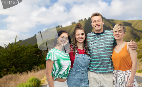 Image of happy friends hugging over big sur hills and road