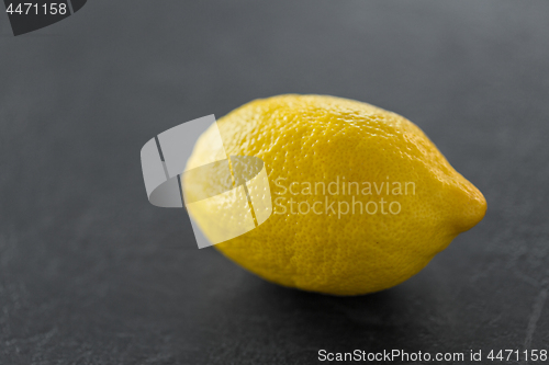 Image of close up of whole lemon on slate table top