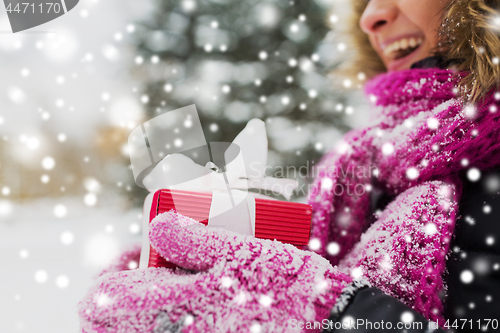 Image of close up of woman with christmas gift outdoors