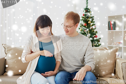 Image of pregnant wife with husband at home at christmas