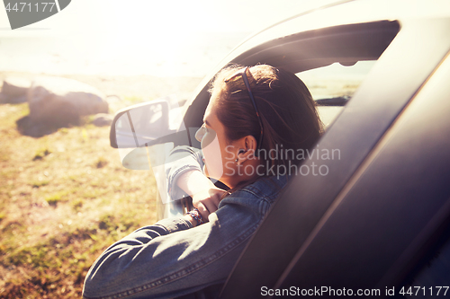 Image of happy teenage girl or young woman in car