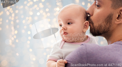 Image of close up of father kissing little baby daughter