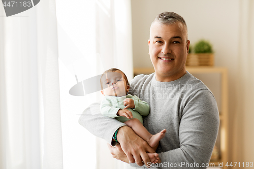 Image of happy father holding with little baby son at home