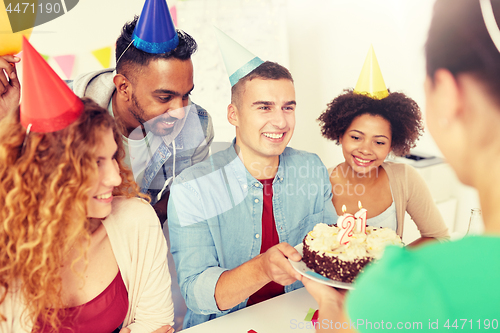 Image of team greeting colleague at office birthday party