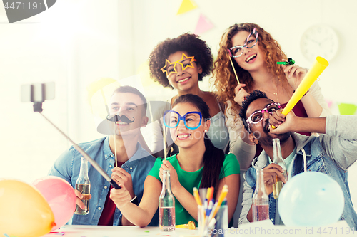 Image of happy team taking selfie at office party