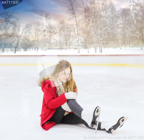 Image of young woman fell down on outdoor skating rink