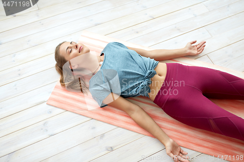 Image of woman doing yoga corpse pose at studio