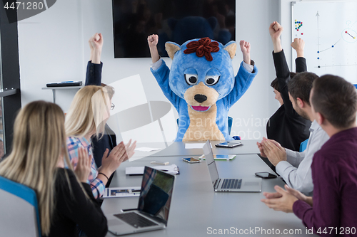 Image of boss dresed as bear having fun with business people in trendy of