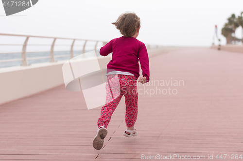 Image of cute little girl on the promenade by the sea