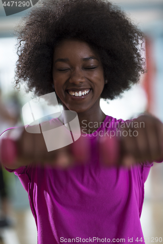 Image of woman working out in a crossfit gym with dumbbells