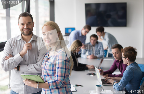 Image of Two Business People Working With Tablet in office