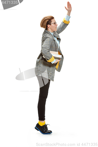 Image of Full length portrait of a happy smiling female student holding books isolated on white background