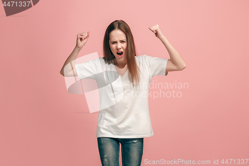 Image of Portrait of angry teen girl on a pink studio background