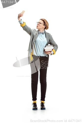 Image of Full length portrait of a happy smiling female student holding books isolated on white background