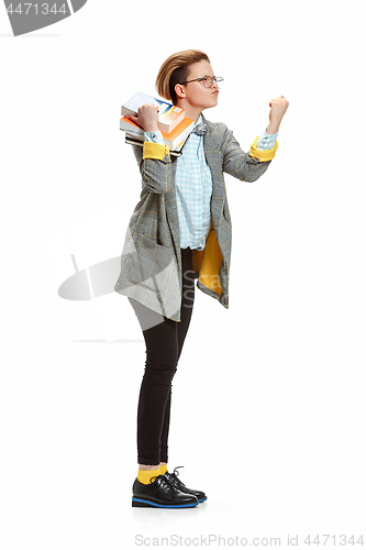 Image of Full length portrait of a angry female student holding books isolated on white background