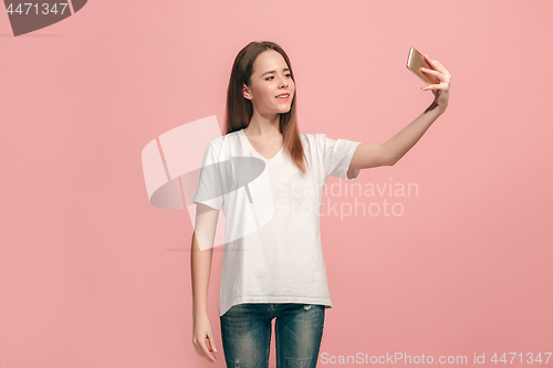 Image of The happy teen girl making selfie photo by mobile phone