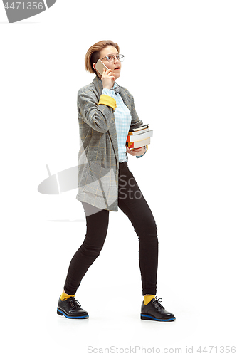 Image of Full length portrait of a surprised female student holding books isolated on white background