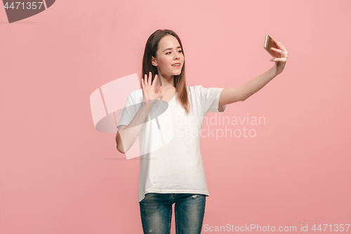 Image of The happy teen girl making selfie photo by mobile phone