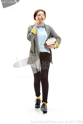 Image of Full length portrait of a surprised female student holding books isolated on white background