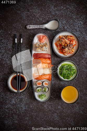 Image of Asian food assortment. Various sushi rolls placed on ceramic plates