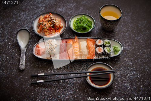Image of Asian food assortment. Various sushi rolls placed on ceramic plates