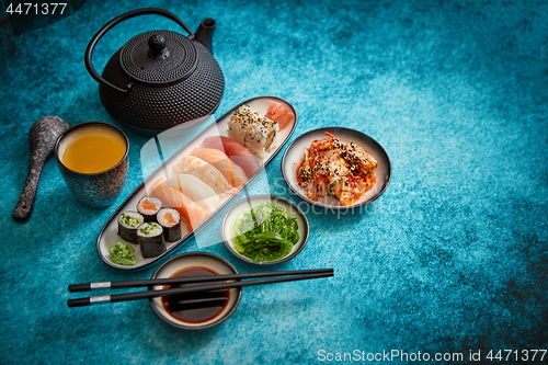 Image of Asian food assortment. Various sushi rolls placed on ceramic plates