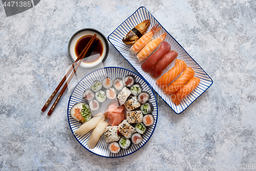 Image of Asian food assortment. Various sushi rolls placed on ceramic plates