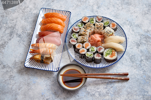 Image of Asian food assortment. Various sushi rolls placed on ceramic plates