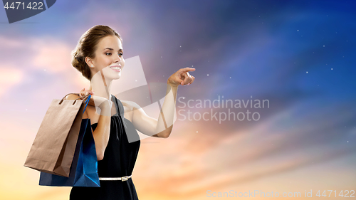 Image of happy woman in black dress with shopping bags