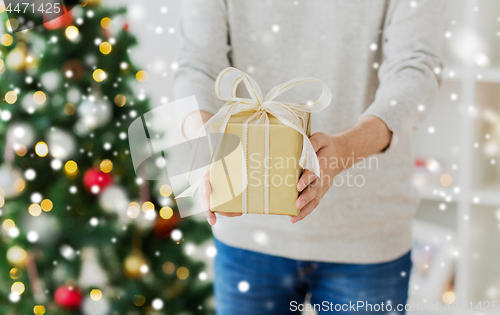 Image of close up of man with christmas gift at home