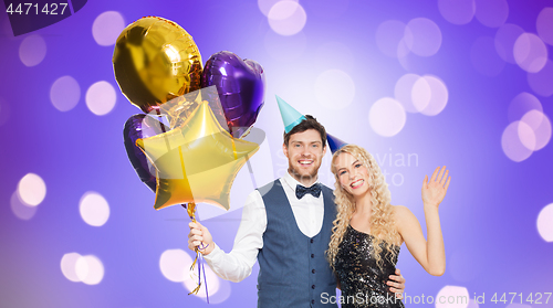 Image of happy couple with party caps and balloons