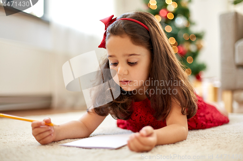 Image of little girl writing christmas wish list at home