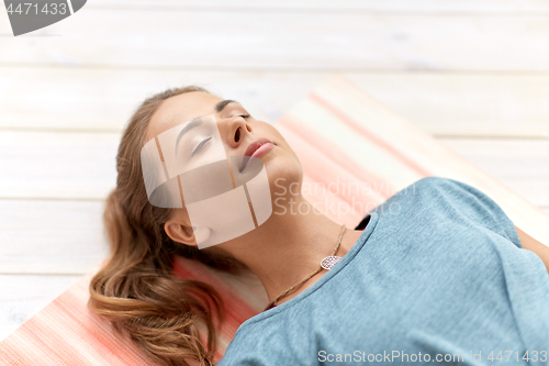 Image of woman doing yoga corpse pose at studio