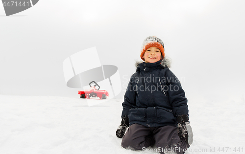 Image of happy boy and sled on snow hill in winter