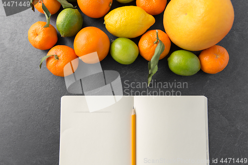 Image of close up of fruits and notebook on slate table top